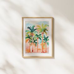 a painting hanging on the wall in front of a white wall with three palm trees