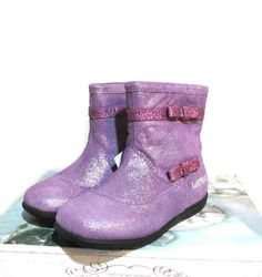 a pair of purple boots sitting on top of a box