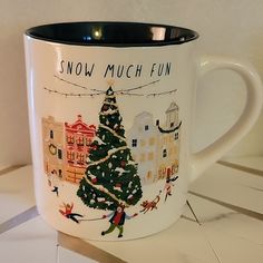 a white coffee mug with a christmas tree on the front and words snow much fun