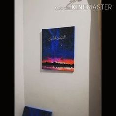 a painting hangs on the wall next to a blue bench in a room with white walls