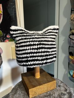 a black and white cat hat on a wooden stand