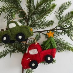 an ornament hanging from a christmas tree with a toy car on it's side