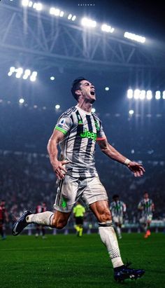 a soccer player is celebrating his goal in front of an audience at a sporting event