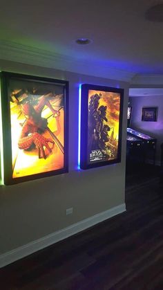 two movie posters are on the wall next to each other in a room with dark wood floors