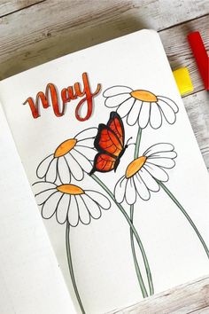 an open notebook with some flowers and a butterfly on the cover that says mym