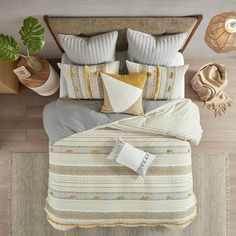 an overhead view of a bed with pillows and blankets on it, along with potted plants