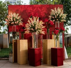 four vases with flowers in them on display