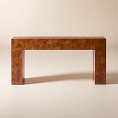 a wooden table sitting on top of a white floor next to a brown wall in the background