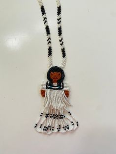 Incredible vintage Native American seed bead handmade necklace. This piece was picked in AZ and is in the shape of a Native American Woman/Girl. This piece is possibly from the Hopi or Navajo tribe. The piece seems to be small glass seed beads with white and black bead designs and made into a beautiful shape of a pretty Native American woman. This is a great piece for collection, use, wear or gift. The fringe is so pretty and check out the beautiful design work on the necklace. Length is approximately 18" long (see pic). Vintage Beaded Pendant Necklace With Large Beads, Vintage Large Beaded Pendant Necklace, Artisan Necklace With Colorful Beads, Vintage Pendant Beaded Necklace With Large Beads, Vintage Style Pendant Beaded Necklace With Large Beads, Artisan White Beaded Necklace With Colorful Beads, Handmade Vintage Pendant Beaded Necklaces, White Hand-strung Long Necklace Beads, White Hand-strung Long Bead Necklace