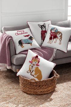 the pillows are on the couch in front of the basket and pillowcase with dogs