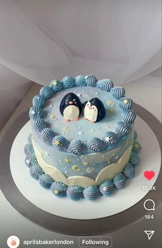 there is a cake with two penguins on it