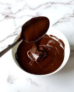 a spoon full of melted chocolate in a bowl