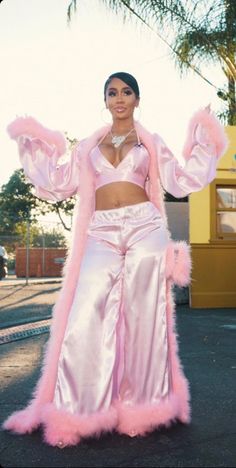 a woman in pink is standing on the street