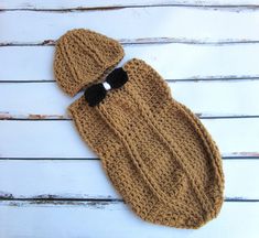 a brown knitted mitt and hat sitting on top of a white wooden table