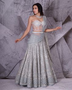 Enveloped between the pastel shade of dusky blue and shimmering traditional embroidery work lies this beautiful lehenga. The corset blouse is embroidered with floral kasab hand work done with stones, sequins and kardanas. The embellished lehenga is the perfect mix of shine with an indo-western feel. The outfit is paired with an attached dupatta with coordinated embroidery to complete the look. Colour : Dusky Blue Fabric : Georgette sari with net blouse Embroidery : 3D floral embroidery done with Corset Blouse Lehenga, Corset Lehenga, Stone Work Lehenga, Lehenga Blue, Embellished Lehenga, Indian Bridal Couture, Beautiful Lehenga, Wedding Edit, Bollywood Theme