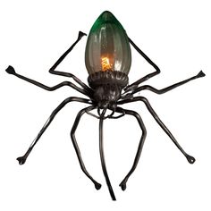 a green light bulb sitting on top of a spider