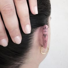 a close up of a person's ear with a small piece of pink ink on it