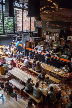 an overhead view of people eating at tables in a large room with lots of windows