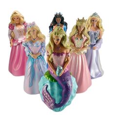 there are four barbie dolls in the same dress and one is wearing a tiara