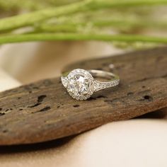 a diamond ring sitting on top of a piece of wood