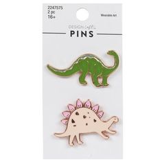 Customize your clothing and accessories with colorful icons that showcase your interests! Dinosaur Enamel Pins are made of rose gold and gold-colored metal and feature a green dinosaur with a long tail and neck and a light pink dinosaur with spikes on its back. Pin them to any fabric item you want to add Jurassic flair to. Dimensions: 	 Length: 7/8" - 1" 	 Width: 1 7/16" - 1 1/2" Package contains 2 pins. Dinosaur Pin, Colorful Icons, Christmas Gift Ideas For Mom, Design Stationary, Wearable Art Fashion, Pink Dinosaur, Green Dinosaur, Gift Ideas For Mom, Cool Pins