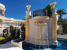 a fountain in front of a building with many windows and balconies on it