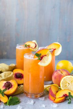 two glasses filled with orange juice and sliced peaches