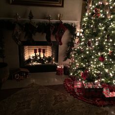 a decorated christmas tree in front of a fireplace