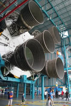 the space shuttle is being displayed in an indoor hanger with people standing around it