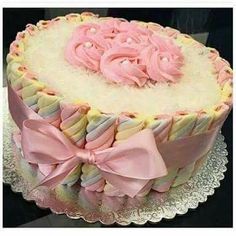 a cake decorated with pink and white icing on top of a glass platter