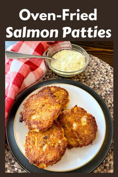 three fried salmon patties on a plate with ranch dip and red checkered towel