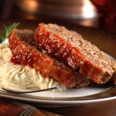 two slices of meatloaf on a plate with mashed potatoes