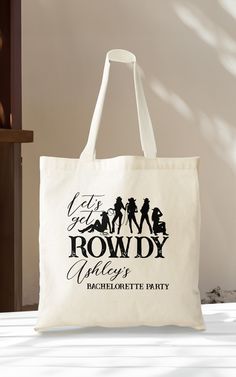 a white tote bag with the words rowdy village on it and silhouettes of people