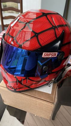 a red helmet with blue visor sitting on top of a wooden table