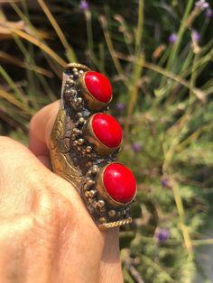 Beautiful vintage tribal saddle full finger ring Red gemstones or glass? Brass intricate carving Adjustable between sizes 9- 11. This is a gorgeous and very unique finger ring. There are three round cut cabochons and I am not sure what they are made of, they could be gemstone or they could be glass. The ring itself appears to be brass and someone could probably give it a good polishing if desired although I think it adds to the character the way it is. The ring Can fit anywhere from a size 9 thr Unique Red Stone Jewelry, Unique Red Jewelry With Stones, Traditional Red Jewelry For Collectible, Traditional Red Jewelry For Collectors, Unique Carved Ring Jewelry, Red Carved Vintage Jewelry, Carved Red Vintage Jewelry, Adjustable Bohemian Ruby Jewelry, Unique Toe Ring Jewelry For Festivals