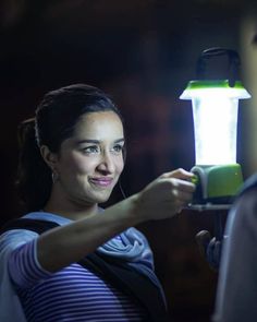 a woman is holding a small light in her hand