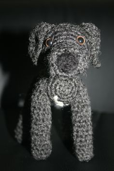 a gray stuffed dog sitting on top of a table