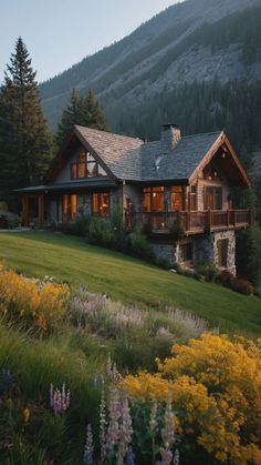 a large house sitting on the side of a lush green hillside next to a forest