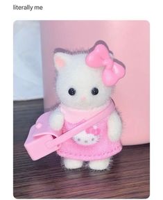 a hello kitty doll with a pink bow on it's head holding a pink object