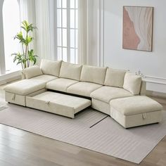 a living room with a large sectional couch and rugs on the hardwood flooring