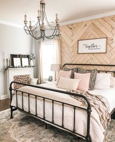 a bedroom with a bed, dresser and chandelier