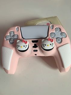 a pink hello kitty game controller sitting on top of a table