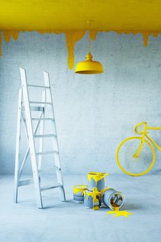 a ladder, paint rollers and a bike are in front of a yellow ceiling