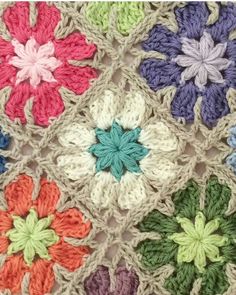 a crocheted blanket with multicolored flowers on it