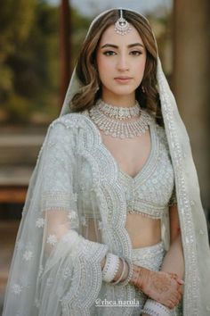 a woman wearing a white outfit and jewelry