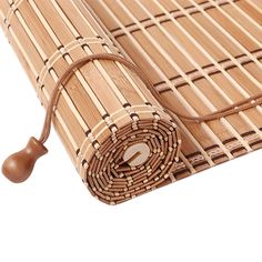 a bamboo mat with a wooden handle laying on the ground next to it's end