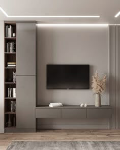 a living room with a large television on the wall and bookshelves in front of it