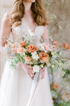 a bride holding her bouquet in front of her wedding party