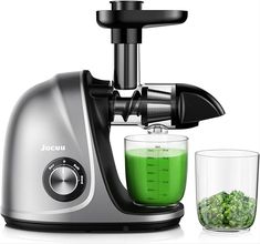 a juicer filled with green liquid next to a glass full of something in it