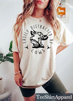 Easily Distracted By Cows Shirt, Cow Lover Shirt, Funny Cow Shirt, Cow Lover Gift, Farm Animal Tshirt, Farmer Shirt, Country Shirt, Cow Tee Sizing and Color Information:  Our shirts are made to order specially for you. For this reason, we don't accept returns or exchanges. To ensure the perfect fit, please refer to our color and size charts before placing your order. If you have any questions, don't hesitate to send us a message to clarify sizing or colors. HOW TO ORDER MULTIPLES: 1. Select your size and color in the drop down menus & add to cart! 2. Then simply go back and repeat for each shirt. If you want to add or change anything on the existing design that we show in the display picture, please contact with us. Product Information: (T-shirts and Long Sleeve T-shirts) Solid colors such White Casual T-shirt With Cow Print, Casual Cotton T-shirt With Cow Print, Casual Cow Print Crew Neck Top, Casual Crew Neck Cow Print Tops, Casual Cow Print Tops With Relaxed Fit, Casual Cow Print Crew Neck T-shirt, Farmer Shirt, Funny Cow, Cow Tshirt